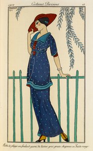 Abito da spiaggia in foulard decorato con grosgrain di tussor, cappello in camoscio rosso. Costumi Parigini n.15. Donna che indossa un abito da spiaggia e una sciarpa di seta grezza rifinita con grosgrain a pois blu e un cappello rosso. da Georges Barbier