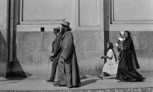 Sacerdote ortodosso russo passeggia sul marciapiede seguito da sua moglie e due figli a Mosca da Gilbert H. Grosvenor