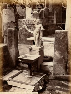 Una fontana composta da una scultura di un giovane ragazzo nudo. La fontana è nella Casa del Balcone pensile, a Pompei