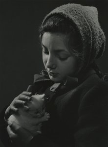 Ragazza che tiene in braccio un gattino bianco. Primi anni 