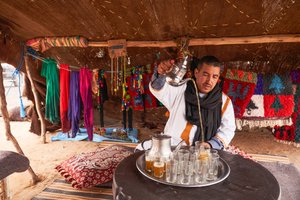 Un locale che serve tè alla menta a Erg Chebbi nel deserto vicino a Merzouga, Marocco, 2019
