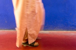 Camminando accanto a un muro blu nel Giardino Majorelle a Marrakech, Marocco, 2014 da Ira Block