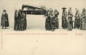 Fratelli della Compagnia della Misericordia che trasportano un malato all