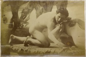 Studio di un modello maschile nudo, sdraiato a terra e lottando con un manichino, nell