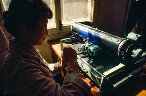 In ufficio comunale un membro digita su una macchina da scrivere cinese. Comune di Chun Xing, Y...