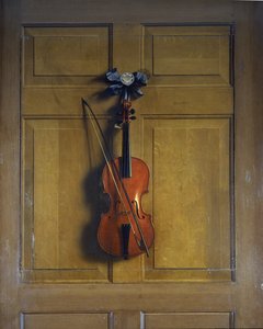 Violino e arco appesi a una porta