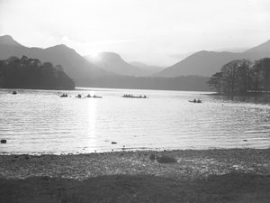 Una vista di persone in canoa sul Derwentwater al sorgere o al tramonto del sole