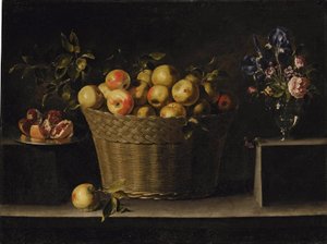 Mele in un cesto di vimini, un melograno aperto su un piatto d
