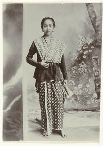 Ritratto in studio di una giovane donna giavanese in un sarong con motivo batik e una camicia a quadretti da Kassian Cephas