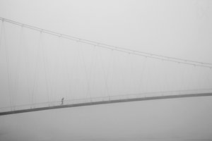 Passeggiata solitaria sul ponte avvolto dalla nebbia