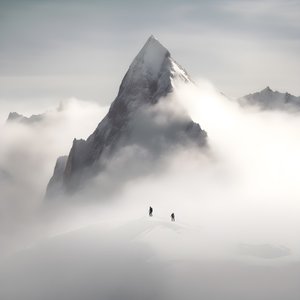 Due persone che sciano su una montagna coperta di nuvole 3