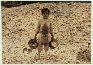 Manuel, raccoglitore di gamberetti migrante di 5 anni, davanti a un mucchio di gusci di ostriche, lavorando per il secondo anno alla Dunbar, Lopez, Dukate Company, Biloxi, Mississippi, 1911