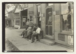 Uomini con cane seduti su una panchina di fronte al negozio generale da Lewis Wickes Hine