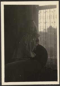 [Bambina appoggiata allo schienale della sedia]