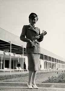 Modella in un completo creato dalla casa di moda "Graldi". Un cappello rigido completa l