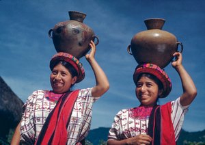 Donne guatemalteche che trasportano brocche d