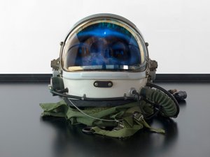 Alpha Omega, 2016 (vetro, schermo LCD, lettore multimediale, teschio replicato, casco spaziale, legno) da Mat Collishaw