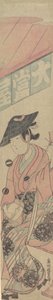 Una geisha seduta su uno shogi davanti a una casa da tè