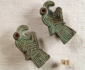 Antichità cristiana: fibule di bronzo intarsiate con granato a forma di teste d