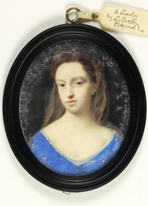 Una signora in corpetto blu con cappuccio marrone