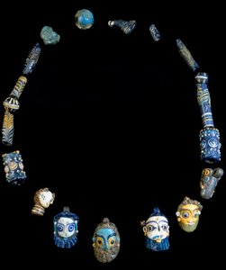 Collana in pasta di vetro con pendenti raffiguranti teste barbute, originaria di Olbia, ora conservata al Museo Archeologico Nazionale di Cagliari