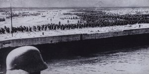 Soldato tedesco che sorveglia prigionieri alleati sulla spiaggia di Dunkerque, Francia, Seconda Guerra Mondiale, giugno 1940 (foto in b/n)