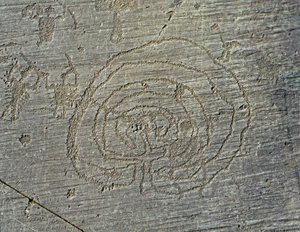 Preistoria, civiltà Camunni, arte rupestre: roccia tombale con la rappresentazione di armi di guerrieri, scudi e spade, e un labirinto. Periodo tra il Neolitico e l