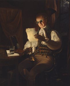 Uomo che legge alla luce di una candela