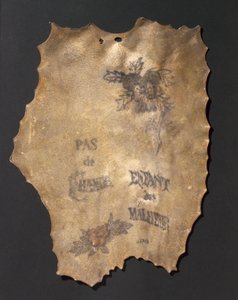 Pelle umana tatuata con fiori e iscrizioni, francese