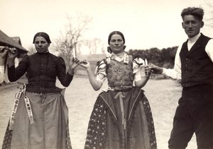 Due donne e un uomo, in abiti tradizionali ungheresi, si tengono per mano in una danza, tenendo alcune candele in mano da Rudolf Balogh