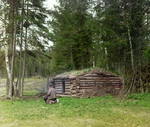 Un uomo davanti a una capanna per taglialegna e kuria (carbonizzazione) nella foresta, Impero Russo, tra il 1905 e il 1915
