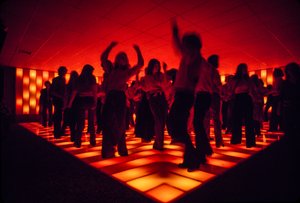 Giovani ballerini in una discoteca che ballano su un pavimento illuminato