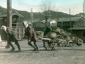 Contadini giapponesi che trainano sacchi di riso su un carro, circa 1900 - 1915 (fotografia)