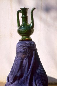 Donna a Kabul nascosta alla vista da un chadri di seta aka chador che trasporta una brocca