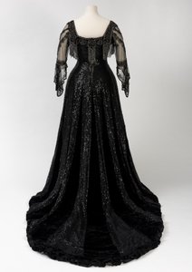 Abito da sera nero indossato dalla Regina Alessandra, con decorazioni di perline e paillettes e incorporante il nastro con il nome della Regina Alessandra, realizzato da Barolet di Knightsbridge, Londra 1908-1910