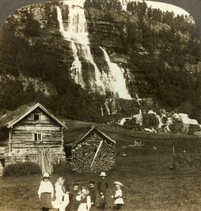 Bambini che giocano in un campo di un contadino con la cascata terrazzata di Tvinde, Vossevangen, Norvegia, c1905