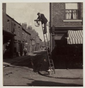 Uomo che pulisce un lampione a gas, circa 1905
