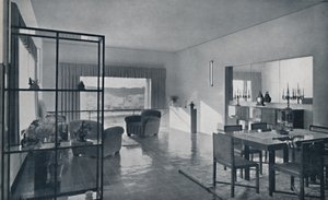 Paniconi e Pediconi. Una sala da pranzo con una grande finestra e tende progettate per incorniciare una bella vista da Unbekannt
