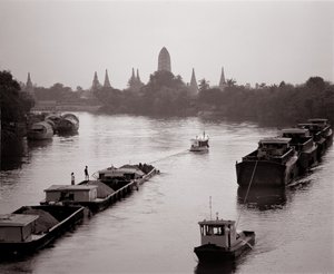 Barche fluviali sul fiume Chao Phraya con vista su Wat Chaiwatthanaram
