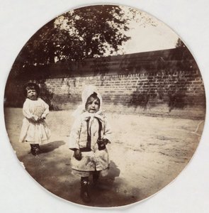 Due bambini piccoli che camminano lungo un muro, circa 1890