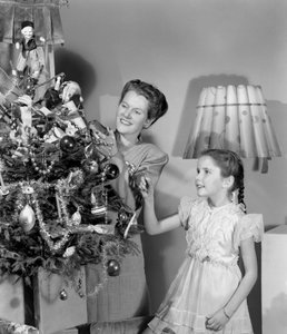 Donna e ragazza che decorano un albero di Natale, c 1948 da Unbekannt