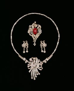 Gioielli Art Deco: spilla pendente in diamanti baguette, spilla a rotolo in rubino cabochon e diamanti, orecchini pendenti in diamanti