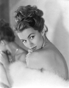 Una giovane donna guarda timidamente oltre la spalla, circa 1948: Ammiccando