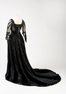 Abito da sera nero indossato dalla regina Alessandra, con decorazioni di perline e paillettes e incorporante il nastro di seta nera e lettere dorate con il nome della regina Alessandra, realizzato da Barolet di Knightsbridge, Londra 1908-1910