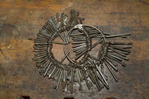 Grande mazzo di vecchie chiavi su anello su scrivania di legno