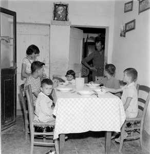 Grande famiglia riunita a tavola nella sala da pranzo della casa di campagna. Anni 1960 da Unbekannt