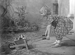 Bambina che gioca con una carriola. Fotografia intorno al 1931