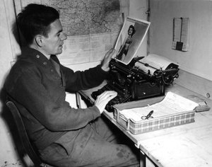 Seconda Guerra Mondiale (1939-1945): Mutzig (Alsazia) Francia 1 dicembre 1944: Il caporale Flanerty cronista del Beachead News guarda una fotografia di pin-up che pubblicherà nel prossimo numero del giornale.
