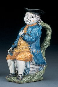 Brocca Toby con volto e mani di colore manganese pallido, che tiene una brocca globulare vuota di colore buff in giacca e pantaloni blu lavato, e gilet verde, c.1800