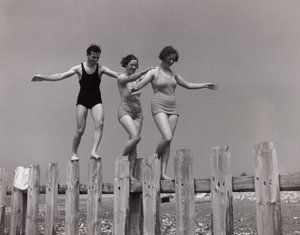 Due donne e un uomo che camminano lungo una diga, c 1930